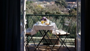 A balcony with a table set for two, overlooking a mountainous landscape. - La Perla Blu (Levanto)