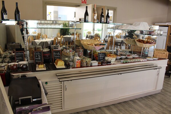 A bakery display with various baked goods and beverages.