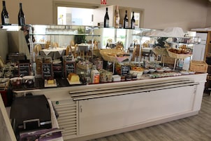 Una vitrina de panadería con diferentes productos horneados y bebidas.