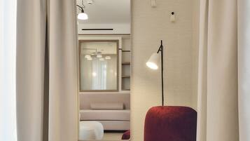A modern room with a red chair, a mirror, and a ceiling light fixture.