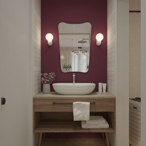 Un baño moderno con un espejo grande, lavamanos blanco y dos luces empotradas.