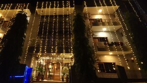 A multi-story building with balconies and string lights.