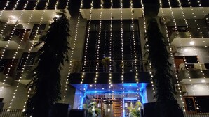 A multi-story building with balconies and string lights.