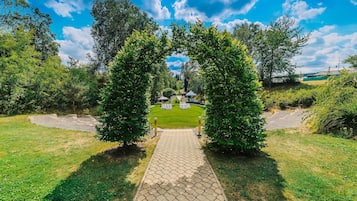 A paved pathway leading to a grassy area with a clear sky above.