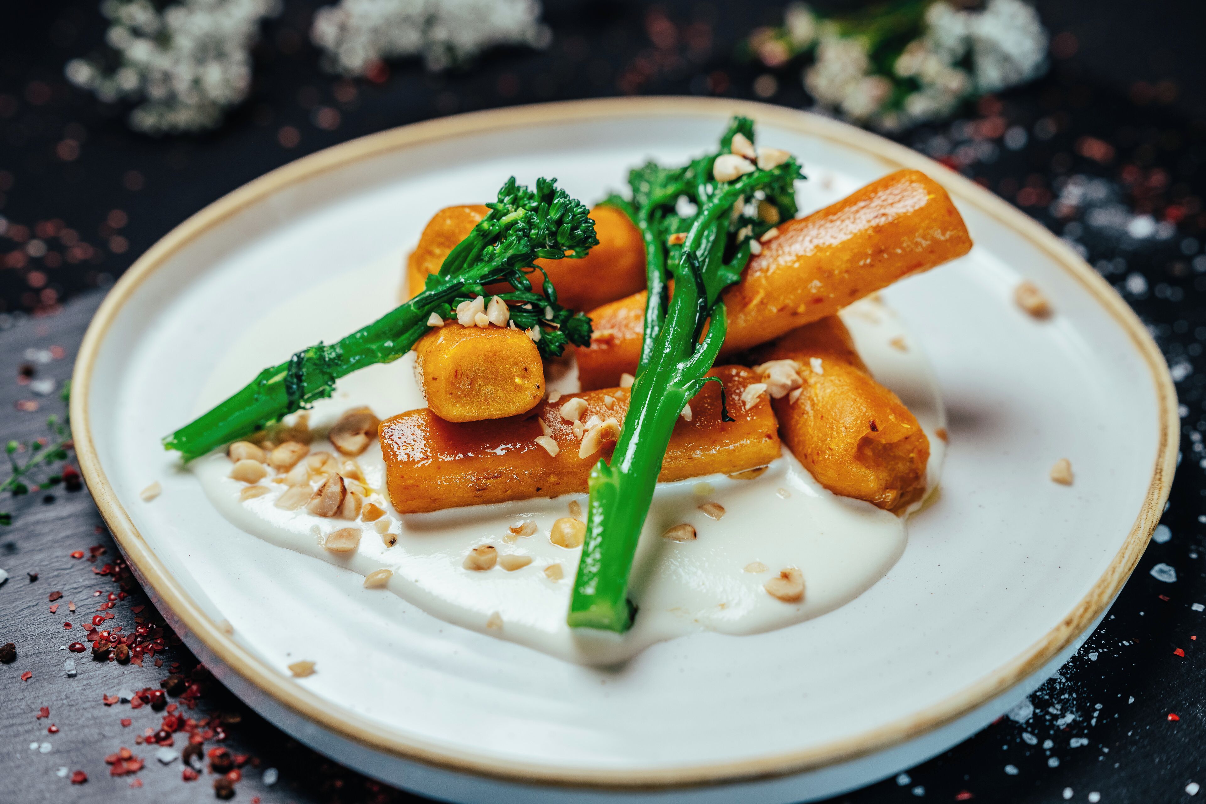 A plate of food with a creamy sauce, garnished with green herbs and nuts.