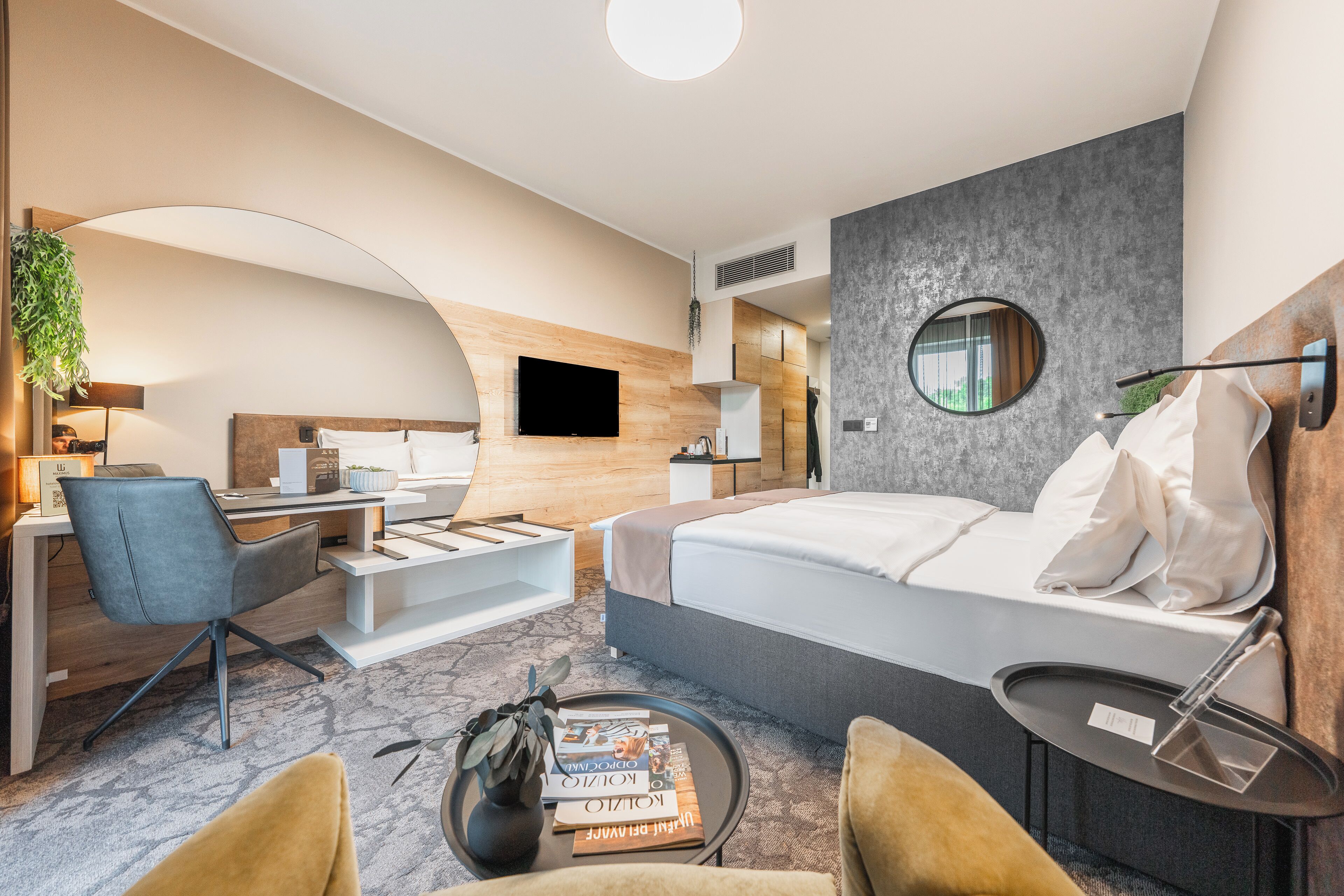 Una habitación de hotel moderna con cama, escritorio y zona de estar.