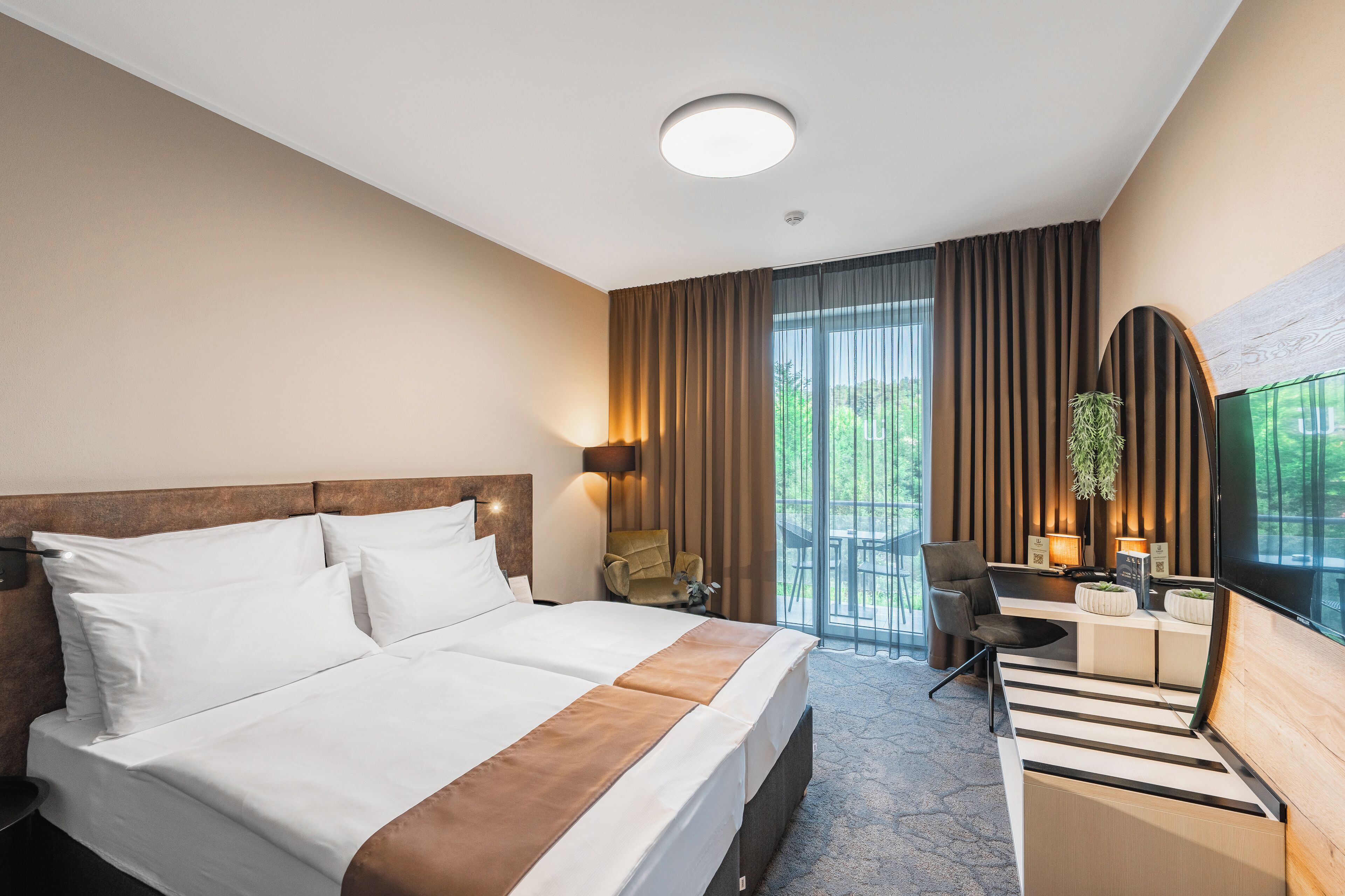 Una habitación de hotel con una cama, un escritorio y una silla.
