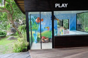 A play area with a glass enclosure, a wooden deck, and a sign that reads 'PLAY'. - Secret Cliff Villa (Karon)