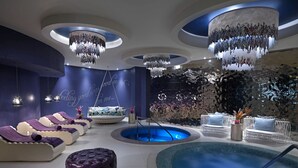 Een luxueus wellnesscentrum met diverse zitplaatsen, een centraal gelegen zwembad en sfeerverlichting.