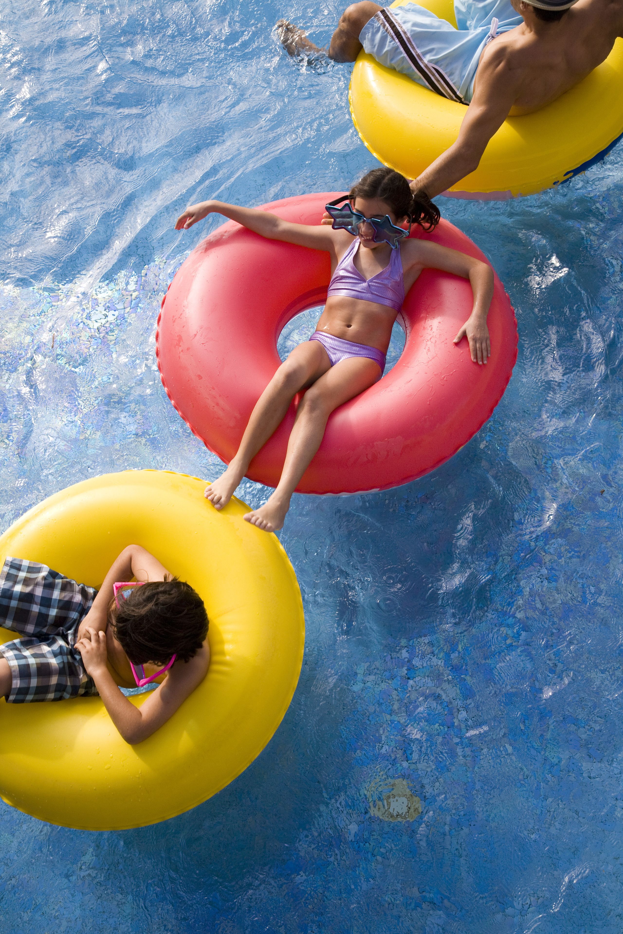 Une piscine où des personnes flottent sur des bouées gonflables.