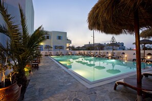 Una piscina al aire libre de temporada, sombrillas