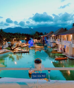 A resort pool area with a sign reading "The Oia Pai," surrounded by overwater bungalows and palm trees. - The Oia Resort Pai (Pai)