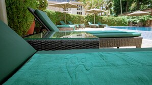 A poolside area with lounge chairs and umbrellas. - SG Premium Resort (Arusha)