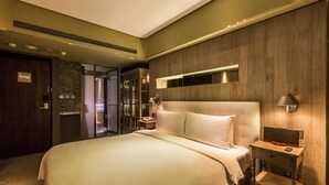 A modern hotel room with a large bed, a bedside table with a lamp, a built-in TV, and a wardrobe. - Inhouse Hotel (Taipei)