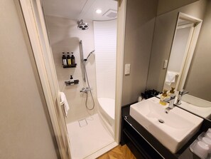 A modern bathroom with a walk-in shower, a double sink vanity, and a large mirror. - Court Hotel Fukuoka Tenjin (Fukuoka)