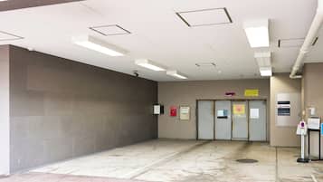 Un vestíbulo limpio y moderno con suelo de baldosas, techo plano con iluminación empotrada y una puerta con un cartel encima.