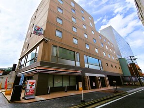Un edificio de varios pisos con una tienda de conveniencia 7-Eleven en la planta baja.
