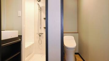 A bathroom with a shower, toilet, and a sink.