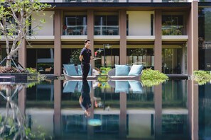 A modern hotel with a reflective pool, outdoor seating, and a well-maintained garden. - Fifth Jomtien Pattaya (Pattaya)