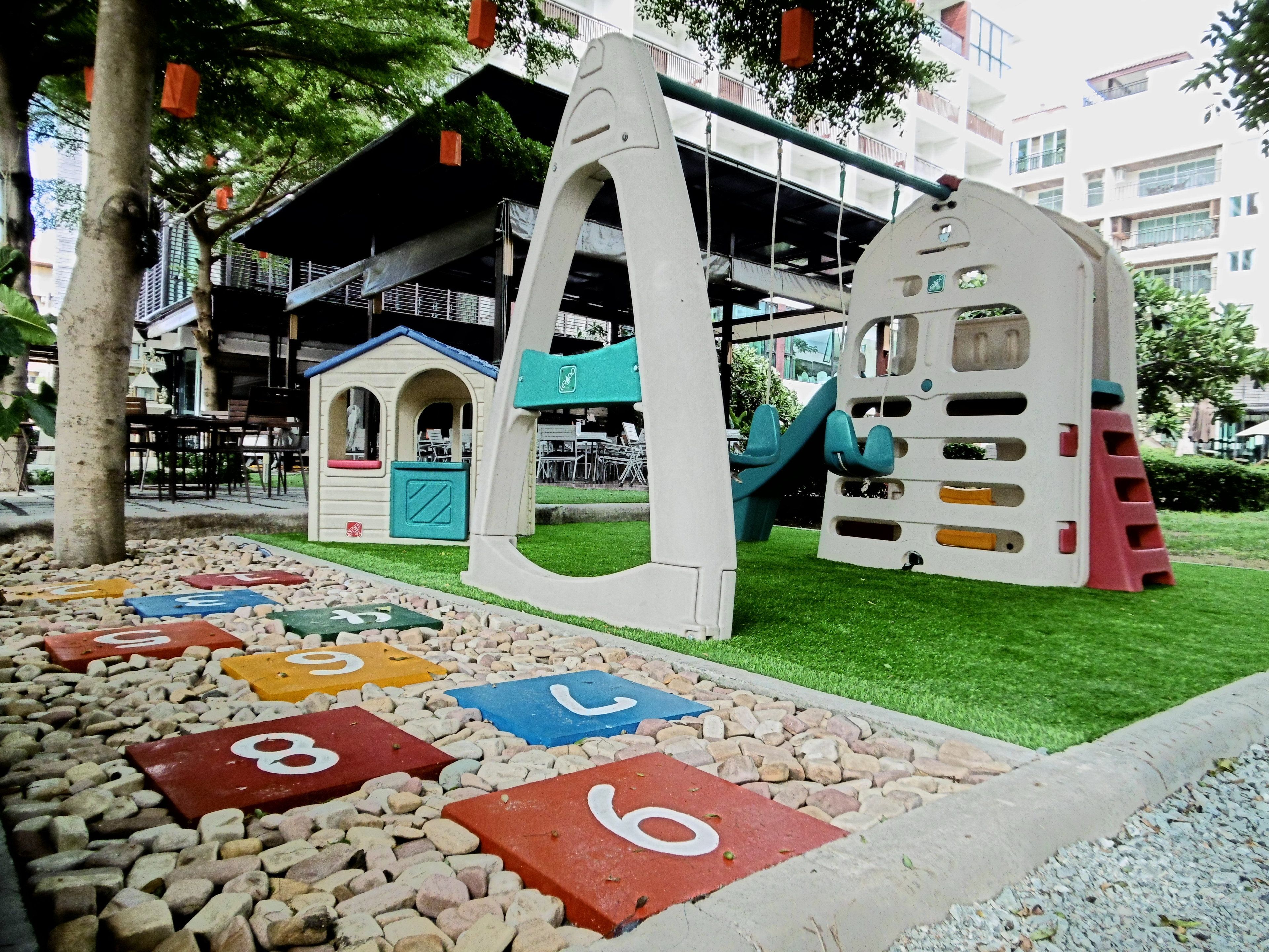 A playground with a climbing structure and a playhouse.