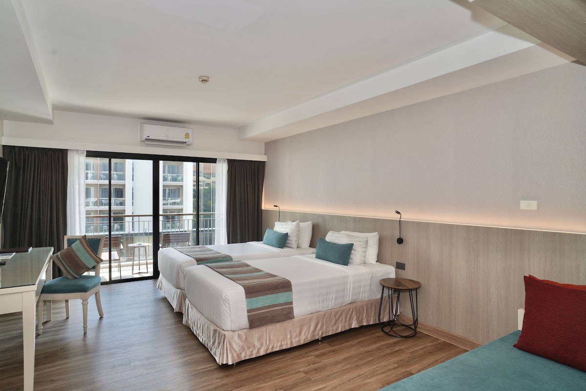 Ein Hotelzimmer mit einem großen Bett, einem Schreibtisch und Blick ins Freie.