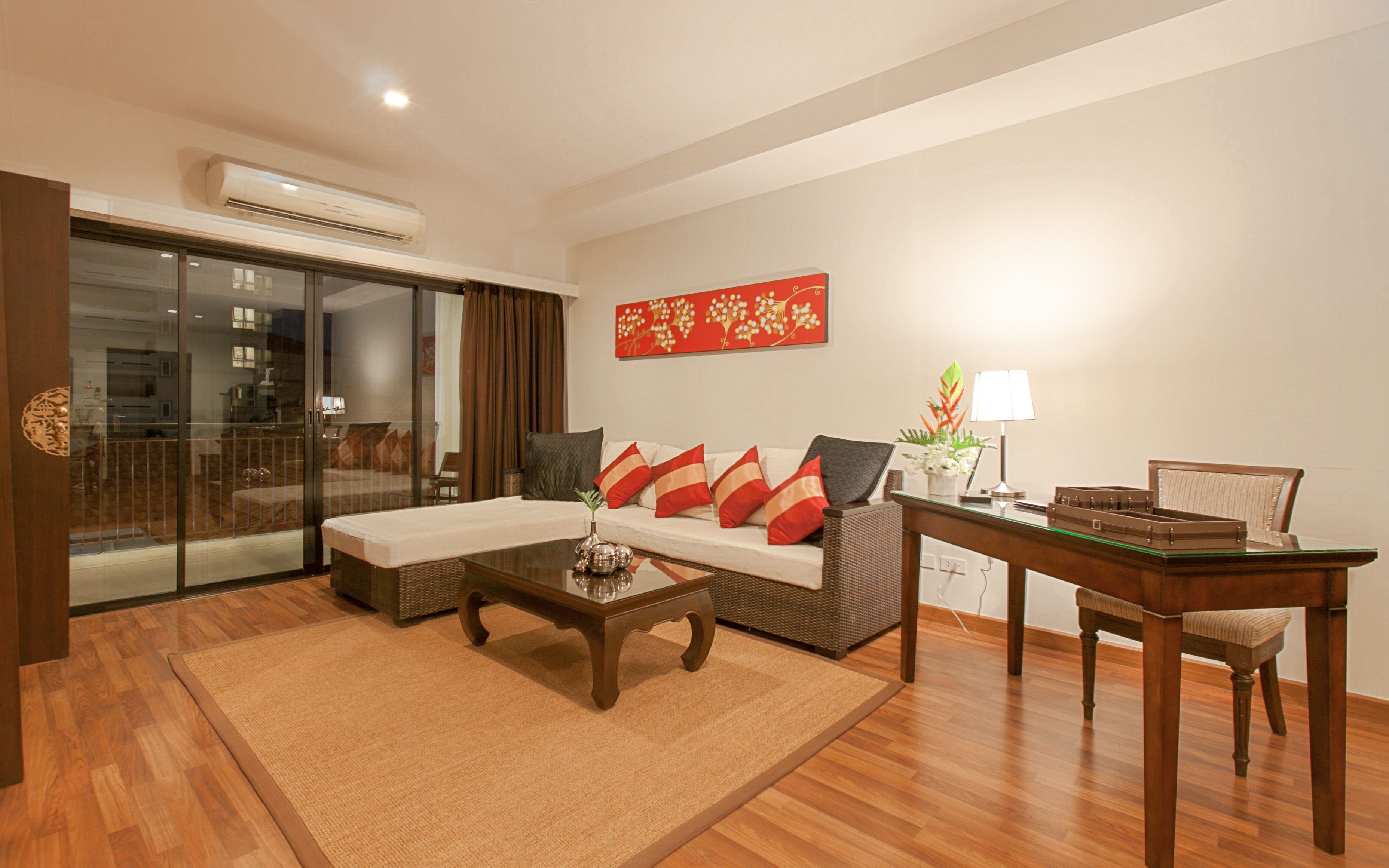 A modern living room with a sofa, coffee table, and a dining area with a table and chairs.