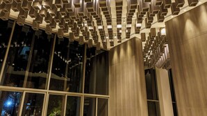 Um interior moderno com design de teto único, grandes janelas e móveis contemporâneos.
