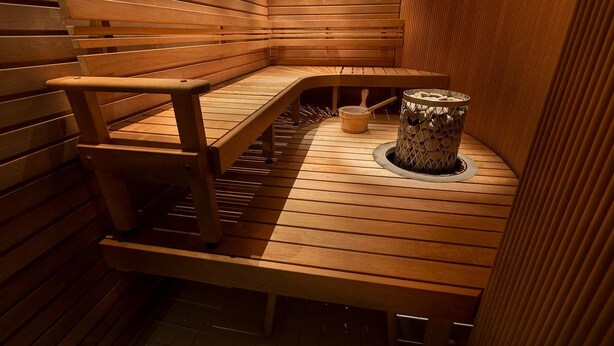 A wooden sauna with benches and a central heating element. - The Headquarters Inn (Nairobi)