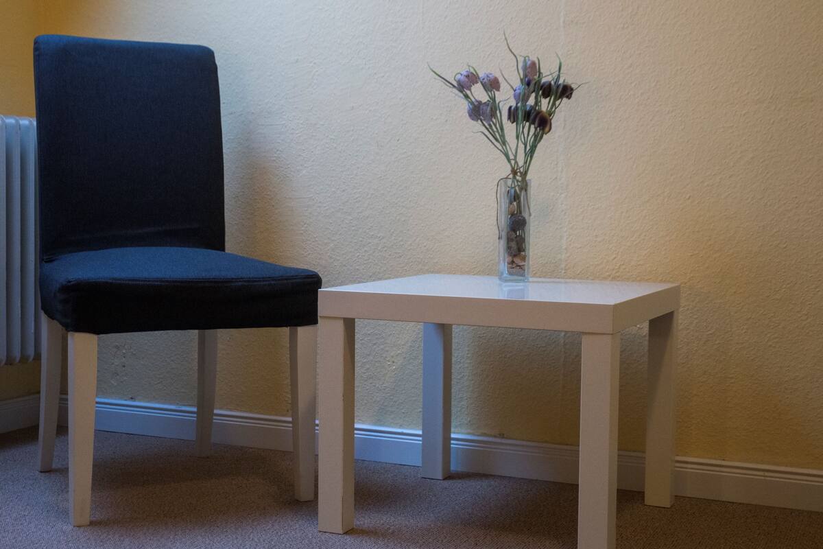 A room with a white table and a blue chair.
