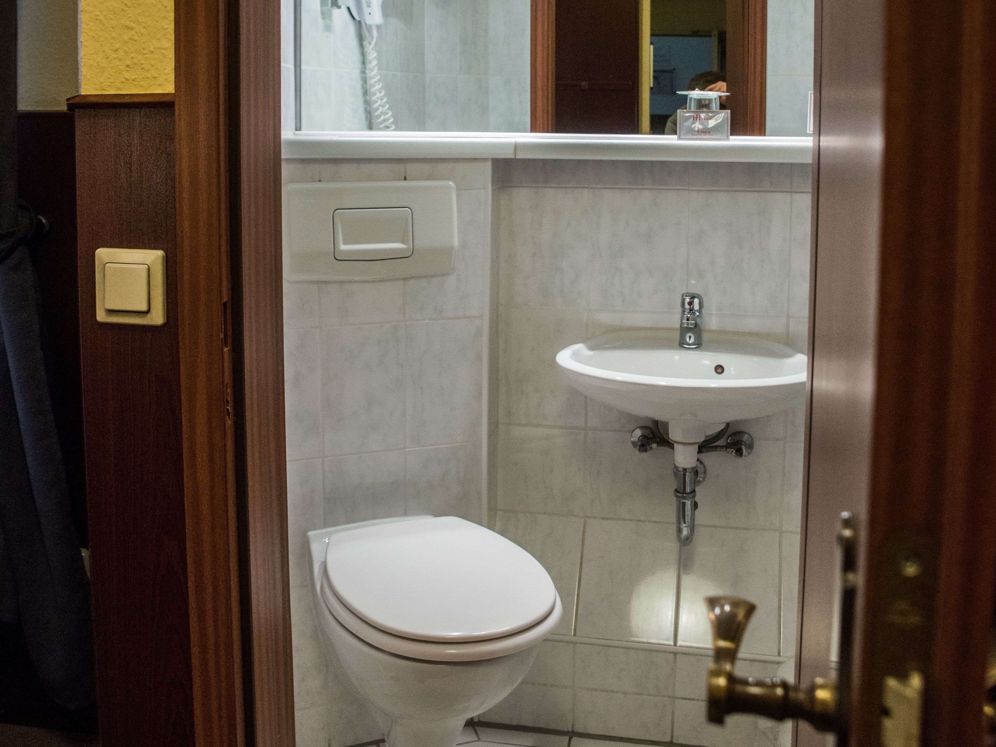 Un baño con inodoro, lavamanos y espejo.