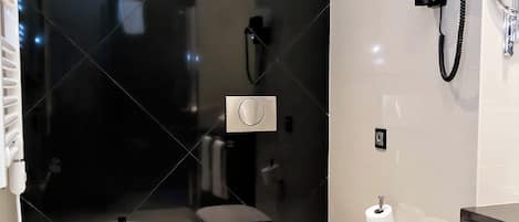 Un baño moderno con un bidé, un inodoro y un lavabo.