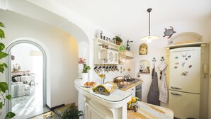Eine Küche mit einer Glasinsel, weißen Schränken und einem Kühlschrank im Vintage-Stil.