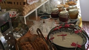 Un bufé con diversos alimentos, como pan, pasteles y frascos de salsas.