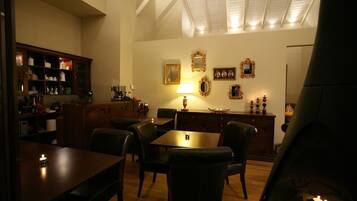 Un espace repas avec des tables et des chaises en bois, un lustre et des décorations murales.