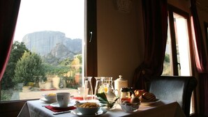 Une table à manger avec des aliments pour le petit-déjeuner et une vue sur une montagne.