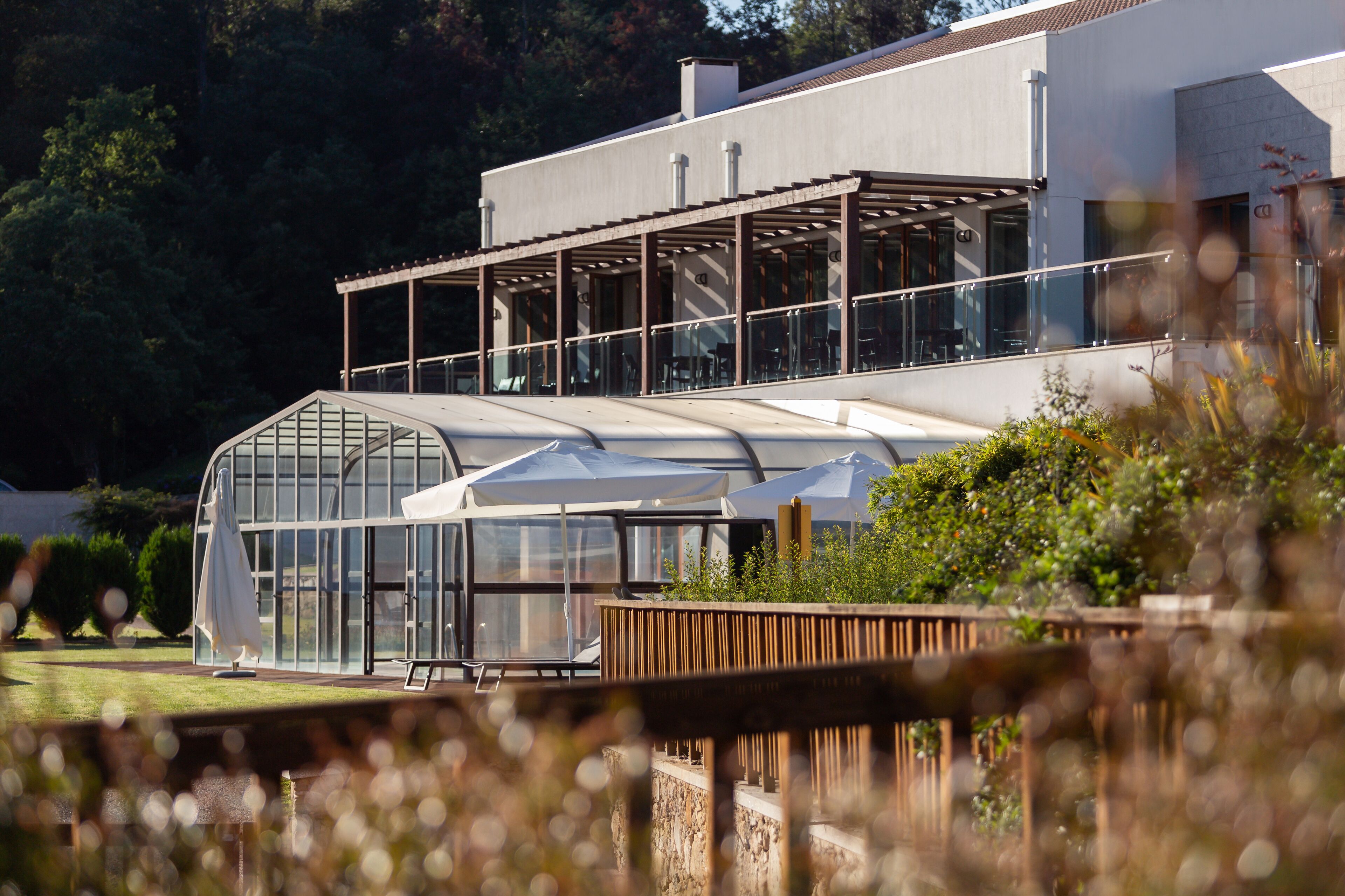 Un bâtiment moderne doté de grandes fenêtres en verre et d’un espace extérieur abrité.