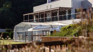Un edificio moderno con amplios ventanales y un espacio exterior cubierto.