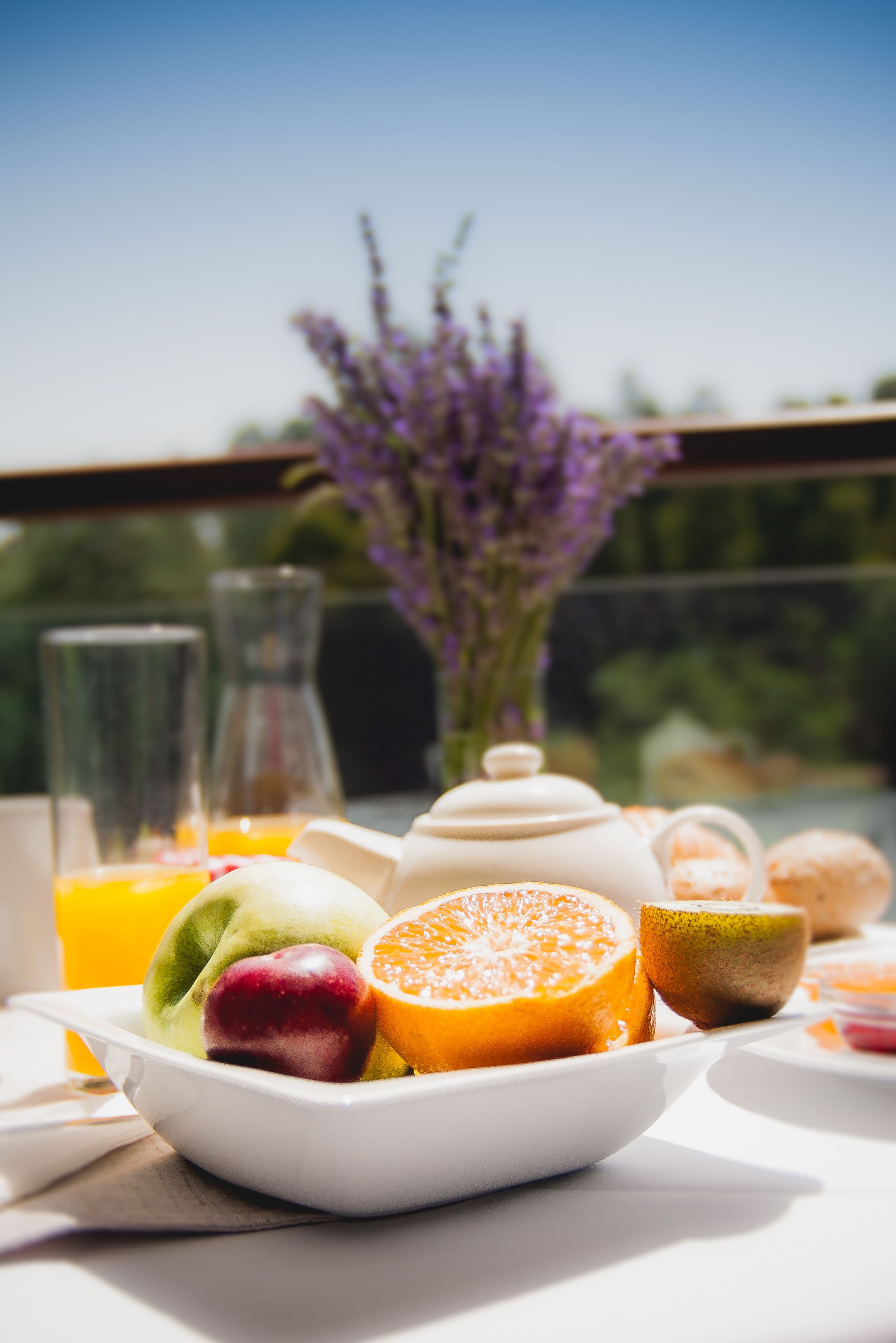 A breakfast setting with a variety of fruits and a glass of orange juice on a table.