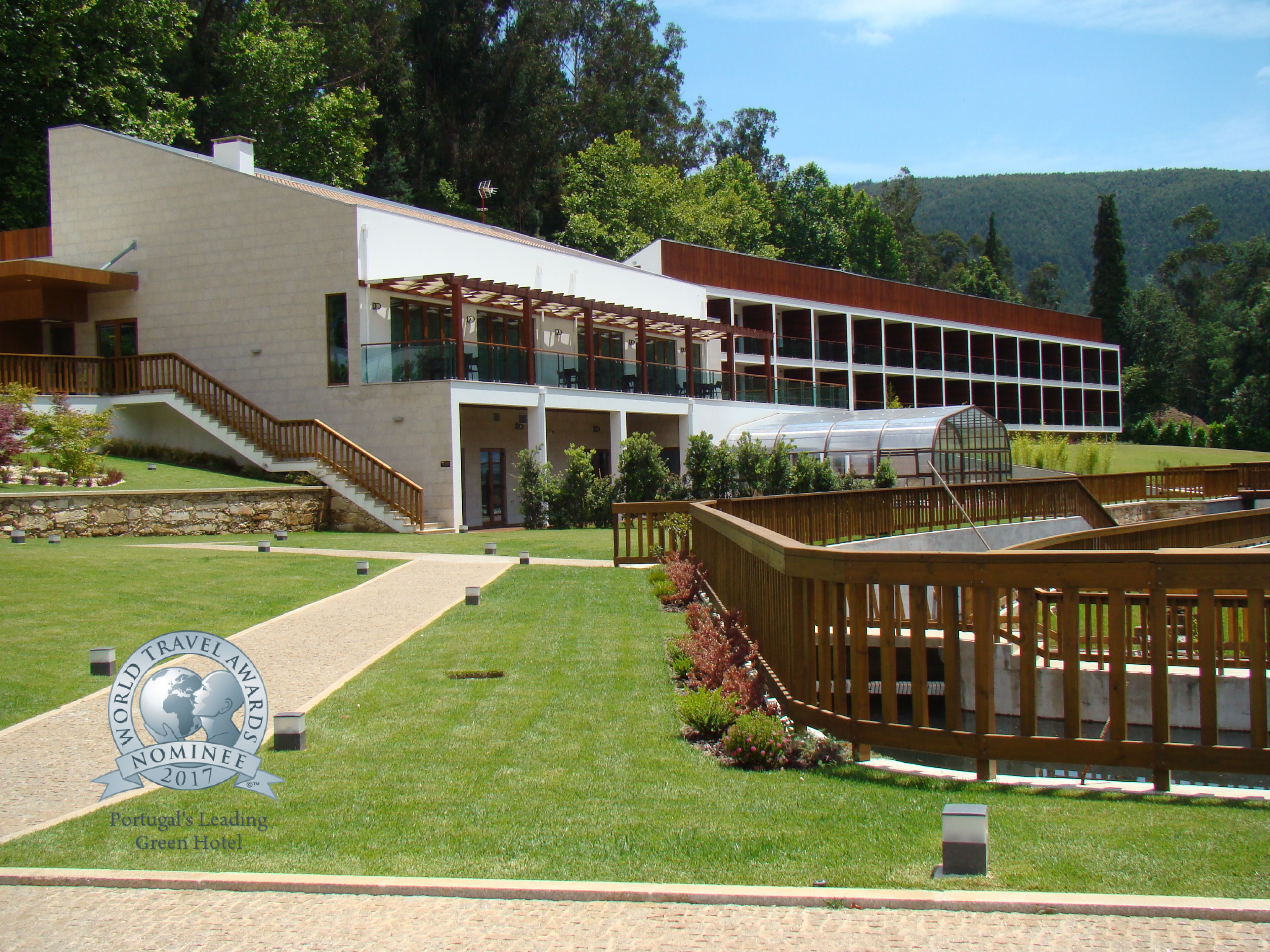 Un hôtel moderne à la structure à deux étages, doté d’un espace extérieur couvert et d’une pelouse bien entretenue.