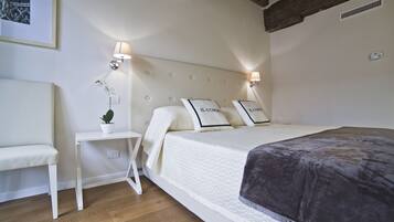 Une chambre à coucher bien rangée, avec un lit, une table de chevet et une petite plante en pot.
