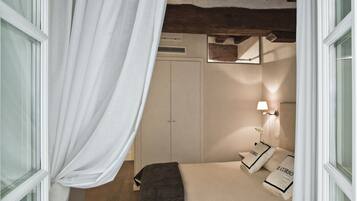 Una camera da letto con un letto, un comodino, una lampada e un armadio.