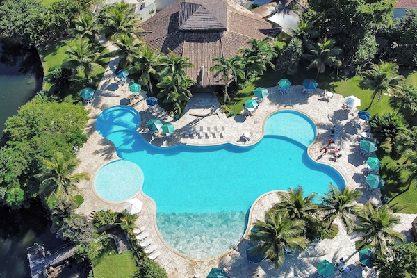 Alberca al aire libre, sombrillas en la alberca y camastros