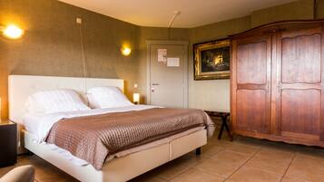 Une chambre d’hôtel comprenant un lit, une table de chevet, une lampe, une armoire et une porte sur laquelle est affiché un avis.