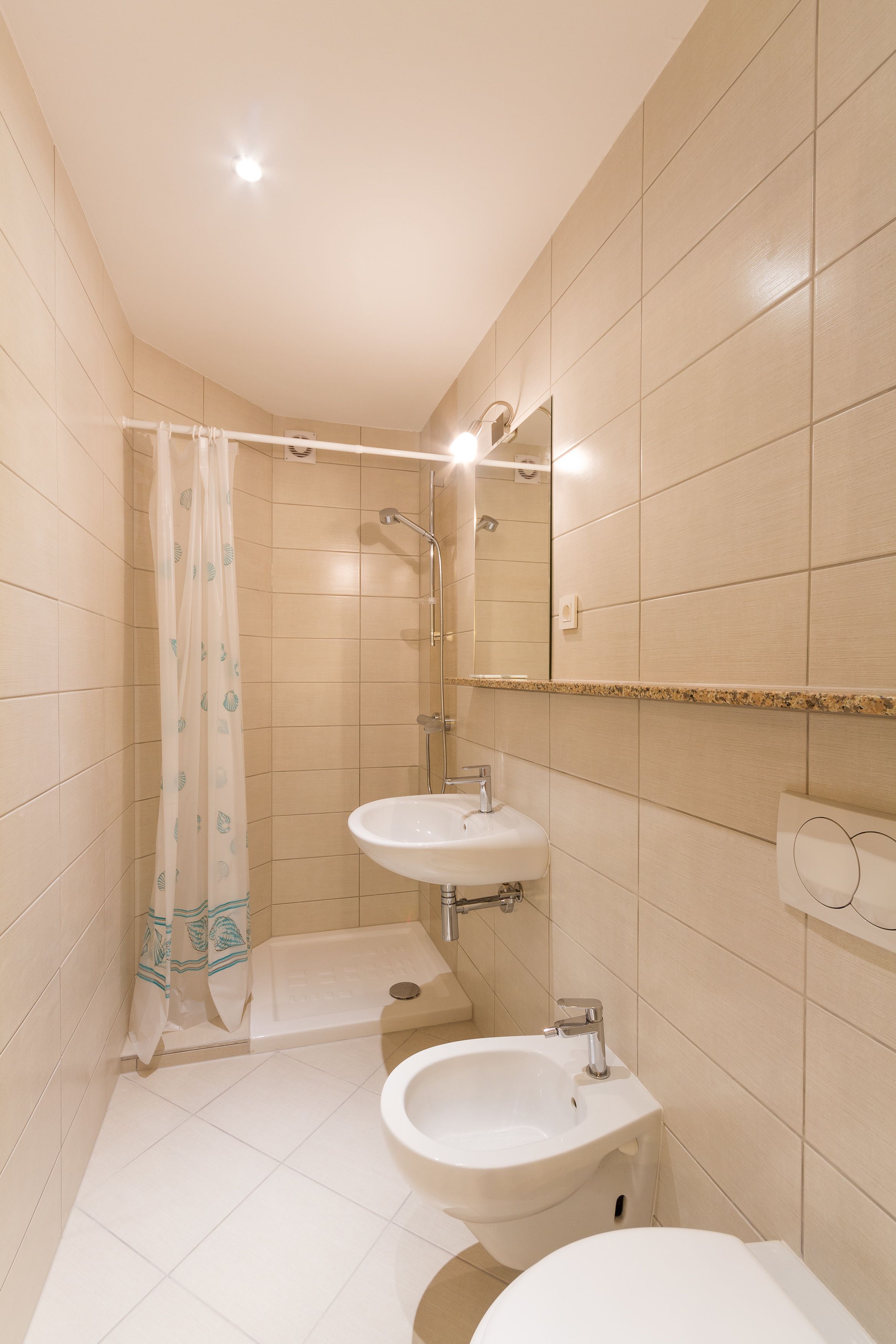 A bathroom with two sinks, a shower, and a mirror.
