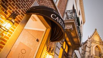 A hotel entrance with a black awning displaying the name "CAELIS".