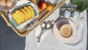 Un'apparecchiatura da picnic con pane, uova e fiori su una tovaglia.