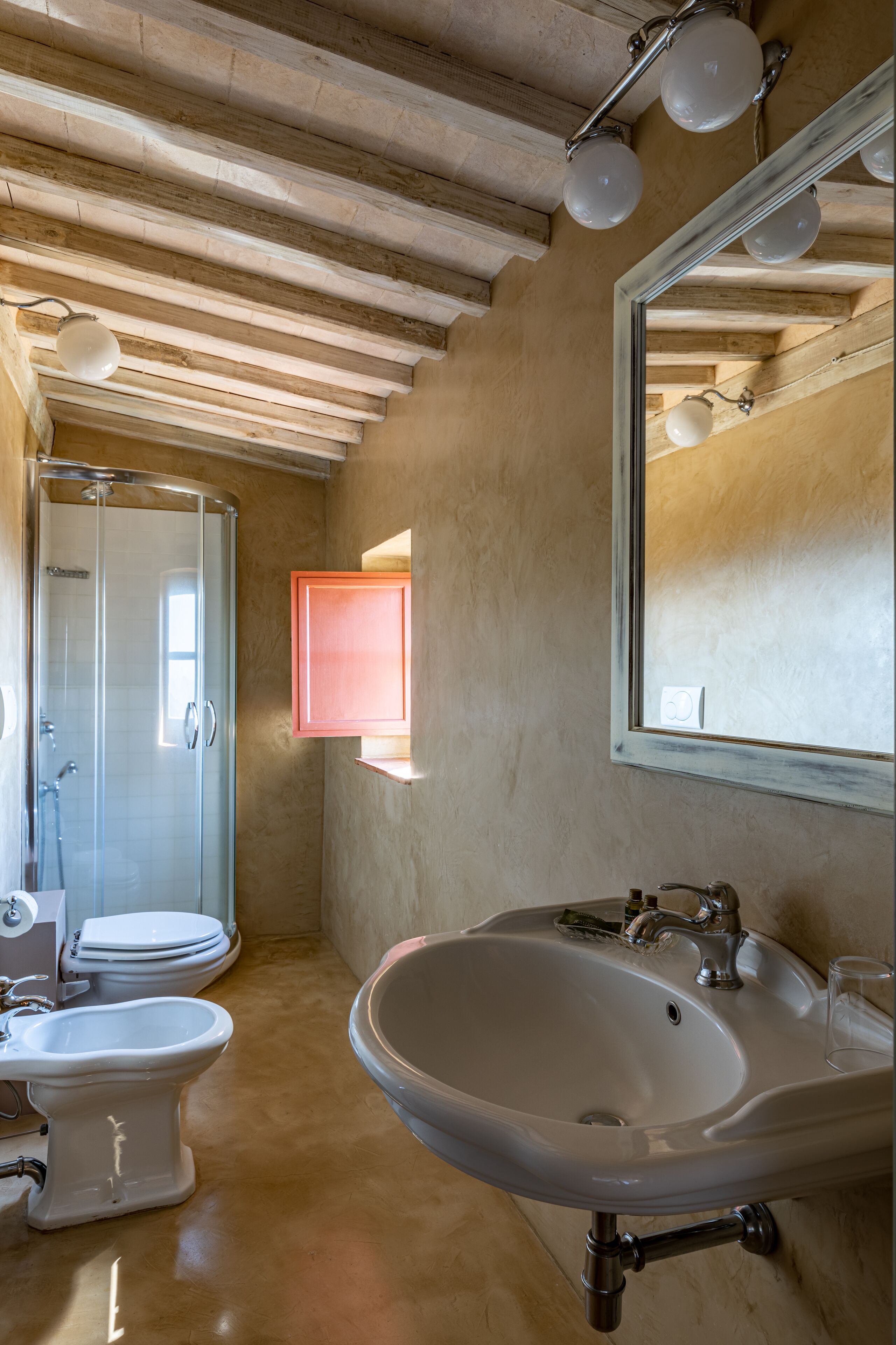 Een badkamer met een douche, een wastafel en een toilet.