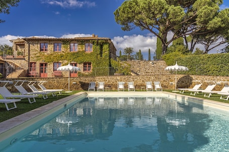 Una piscina al aire libre de temporada, sombrillas