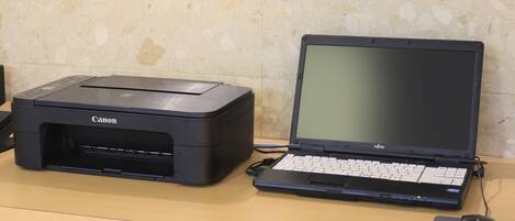 A Canon printer and a Fujitsu laptop on a desk with a mouse.