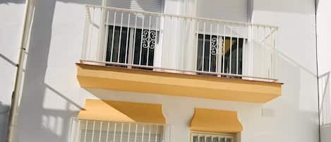 Un edificio de dos pisos con balcones, una puerta de garaje y un letrero con el número 44.